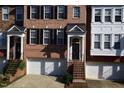 Up close exterior of a charming brick townhome with black shutters and a one-car garage at 2507 Princewood St, Raleigh, NC 27612