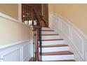 Interior view of a wooden staircase with white risers, detailed trim, and a wooden banister at 2507 Princewood St, Raleigh, NC 27612