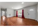 Bright living room featuring hardwood floors, a large window, and fresh paint, creating an inviting atmosphere at 2512 Mckinney St, Burlington, NC 27217