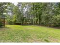 Wide view of the lawn in the large, tree lined backyard showing plenty of space for outdoor enjoyment at 2712 Pebblebrook Dr, Sanford, NC 27330