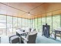 Enclosed sunroom with seating, table, grill, and natural light streaming through the screened windows at 2712 Pebblebrook Dr, Sanford, NC 27330