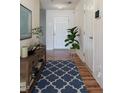 Stylishly staged hallway with wood floors, decorative rug, and console table, enhancing the home's appeal at 305 Wallington Ct, Mebane, NC 27302