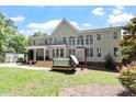 Spacious backyard with covered porch, multiple windows, and a hot tub for outdoor relaxation at 312 Flint Point Ln, Holly Springs, NC 27540