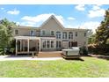 Large backyard featuring a covered porch, multiple windows, hot tub, and ample outdoor space at 312 Flint Point Ln, Holly Springs, NC 27540