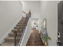 Grand entryway showcasing a staircase with carpeted steps and a wrought iron banister at 3215 Retama, New Hill, NC 27562