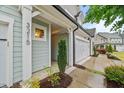 Stylish townhome exterior with a covered entrance, number marker, and lush landscaping at 3215 Retama, New Hill, NC 27562