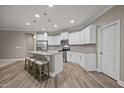 Bright kitchen with white cabinets, stainless steel appliances, granite countertops, and island with bar stools at 35 Clubhouse Dr, Youngsville, NC 27596