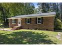 Cozy brick home with a well-kept lawn, black shutters, and a welcoming front entrance at 37 Weeping Willow Ln, Lillington, NC 27546
