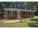 Classic brick home featuring a charming entrance with brick steps and mature shade trees at 37 Weeping Willow Ln, Lillington, NC 27546