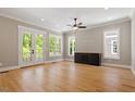 Bright and airy living room featuring hardwood floors, ceiling fan, and doors to an outdoor deck at 3934 Old Chapel Hill Rd, Durham, NC 27707
