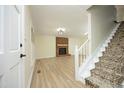Spacious living room featuring a brick fireplace and staircase to the upper floor at 409 Glaive Dr, Durham, NC 27703
