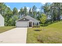 Inviting single-story home featuring a spacious driveway, attached garage, and lush green lawn at 418 Ivy Bank Dr, Angier, NC 27501