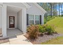 Close-up of the front entrance showing a cozy porch with decorative columns and a well-maintained garden at 418 Ivy Bank Dr, Angier, NC 27501
