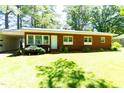 Well-maintained brick ranch home with a lush green lawn and ample shade trees at 452 N Main St, Wendell, NC 27591