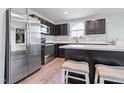 Modern kitchen featuring stainless steel appliances, dark cabinetry, and a center island with seating at 46 Bellini Dr, Angier, NC 27501
