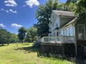 Large backyard with wooden deck, lawn, and mature trees at 4917 Harbour Towne Dr, Raleigh, NC 27604