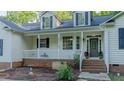 Traditional home with a welcoming front porch, brick accents, and lush landscaping at 5307 Green Riley Rd, Rougemont, NC 27572