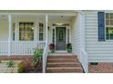 Inviting front porch with brick steps, decorative plants, and white railings enhance curb appeal at 5307 Green Riley Rd, Rougemont, NC 27572