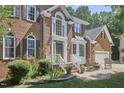 A well-maintained brick home with manicured landscaping, a two-car garage and a cozy front porch at 5328 Willow Cry Ln, Raleigh, NC 27613