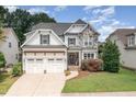 Charming two-story home featuring a stone facade, a three-car garage, and a well-manicured lawn at 5629 Clearsprings Dr, Wake Forest, NC 27587