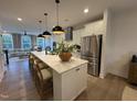 Bright, open kitchen featuring a large island, stainless steel appliances, and hardwood floors at 5900 Dunzo Dr, Raleigh, NC 27617