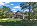 Inviting two-story home with a green lawn, mature trees, and a long driveway on a sunny day at 6332 Mountain Oaks Way, Wake Forest, NC 27587