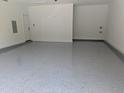 Spacious garage with a durable, speckled floor coating and white walls, offering ample storage and parking space at 703 E Markham Ave, Durham, NC 27701