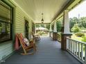 Inviting front porch featuring rocking chairs, wood flooring, and classic columns at 714 Spring Ln, Sanford, NC 27330