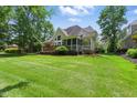Expansive backyard featuring a lush lawn, mature trees, and a wooden deck with a screened porch at 812 Bear Tree Crk, Chapel Hill, NC 27517