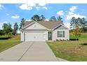 Inviting single-story home with a manicured lawn, concrete driveway, and a classic facade at 87 Royal Meadow Dr, Angier, NC 27501
