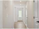 Bright hallway featuring neutral walls, hardwood floors, recessed lighting, and a glass-paneled door at 87 Royal Meadow Dr, Angier, NC 27501