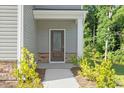 Close up view of home's front door with stone accents and well-kept landscaping at 94 Taverners Ln, Angier, NC 27501