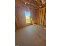 Bedroom under construction with exposed wood frame, window view, and unfinished concrete floor at 95 Bald Cypress Ln, Youngsville, NC 27596