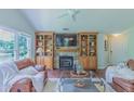 Inviting living room with stone fireplace, custom built-ins, hardwood floors, and large windows with views at 0317 Glen Echo Ln # C, Cary, NC 27518