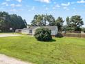Scenic view of house with basketball court, storage shed, large front yard and wood fence at 111 Marshay Meadow Rd, Youngsville, NC 27596