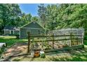 Well-kept backyard garden with a greenhouse and different plants surrounding the area at 1205 Hillsborough Rd, Chapel Hill, NC 27516