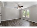 Living room features hardwood floors, ceiling fan, and large window views at 136 Dixie Ln, Youngsville, NC 27596