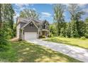 Inviting two-story home featuring an attached garage, lush green lawn, and a serene tree-lined backdrop at 1417 Westmoreland Dr, Raleigh, NC 27612