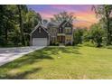 Charming two-story home featuring a lush green lawn under a vibrant sunset sky at 1417 Westmoreland Dr, Raleigh, NC 27612