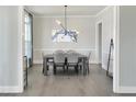 Elegant dining room with modern lighting, a stylish table set for six, and beautiful hardwood flooring at 1425 Sierra Glen Cir, Apex, NC 27502