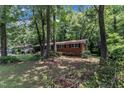 A cozy brick home surrounded by mature trees and a grassy lawn, creating a peaceful setting at 1500 Lakeside Dr, Garner, NC 27529