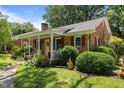 Inviting brick home with a cozy, covered porch and decorative shutters at 1542 W Davis St, Burlington, NC 27215