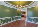 Elegant dining room with decorative molding, hardwood floors and a chandelier lighting at 168 Melody Ln, Cameron, NC 28326