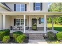 Inviting front porch with classic white rocking chairs and manicured landscaping at 1726 Rapids Ct, Franklinton, NC 27525