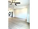 Open-concept living room with modern ceiling fan and sleek flooring adjoining kitchen at 189 Seville Way, Clayton, NC 27520