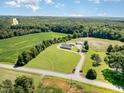 Scenic aerial view of home nestled among green fields and dense trees in a rural setting at 190 Mitchells Chapel Road, Pittsboro, NC 27312