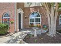 A welcoming front porch with beautiful landscaping, including a birdbath, and flowering plants at 2101 Piney Brook Rd # 102, Raleigh, NC 27614