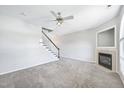 Bright living room featuring a fireplace, neutral carpet, a ceiling fan and staircase at 2101 Piney Brook Rd # 102, Raleigh, NC 27614