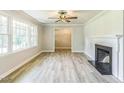 Bright living room boasts laminate floors, large windows, and a cozy fireplace with a white mantle at 2300 Radius Cir, Sanford, NC 27330