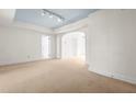 Spacious living room with neutral carpeting, white walls, light blue ceiling, and ample natural light offers a versatile living space at 235 Mccauley St # D, Chapel Hill, NC 27516